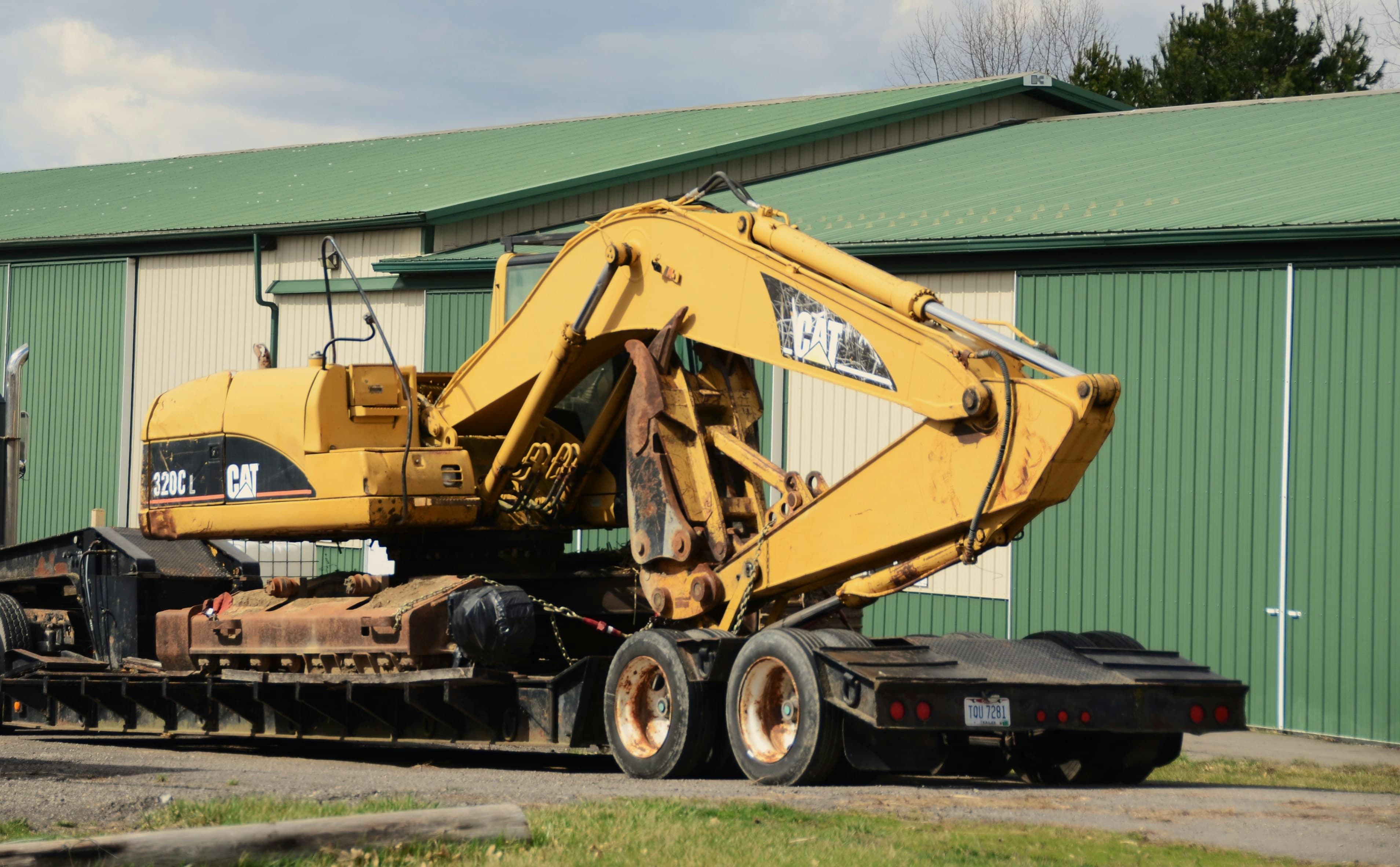 Yellow tracked excavator loaded on a low-deck equipment trailer